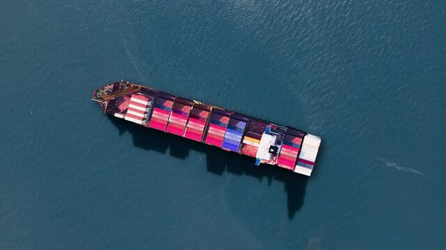 Container ship navigating through calm waters with colorful shipping containers on board during global trade operations