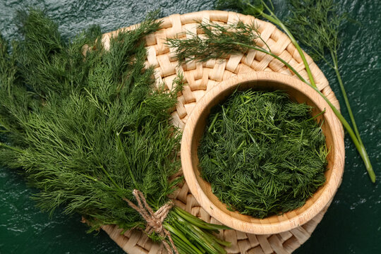Bowl with fresh dill on green background