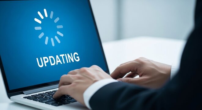 Laptop displaying an 'updating' screen with hands typing representing software installation or progress