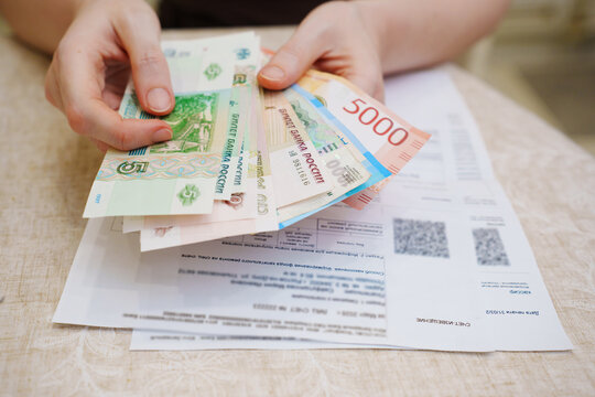 Different methods for paying utility bills in a household setting with cash and bills in hand