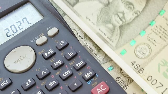 India commerce financial year (FY) 2026 - 2027 tax calculating, budget planning, finance management, cost accounting and business development concept. Hand closeup counting indian rupee currency notes