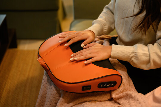 Detailed shot of hands resting on an ergonomic massage pillow, highlighting hand therapy, stress relief, and self-care lifestyle