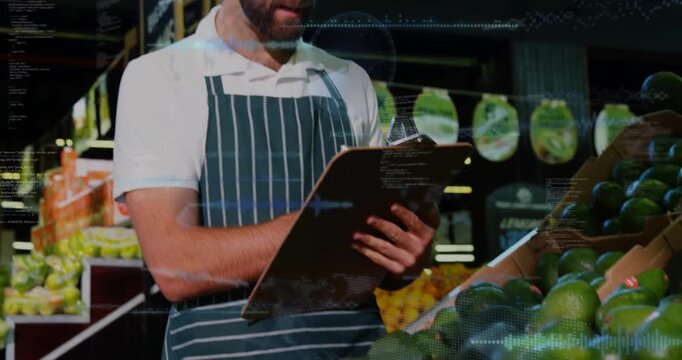 Camera widening produce clerk checking avocados writing stock on pad with pen overlays crossing pad