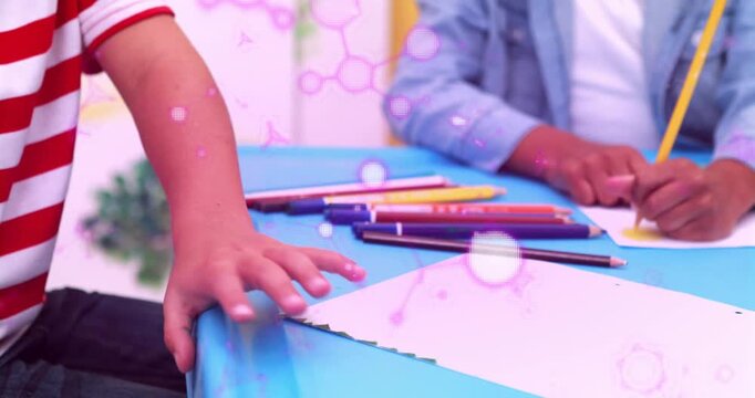 Boy grabbing green pencil, drawing on blue table while pink dots floating over paper, learning art
