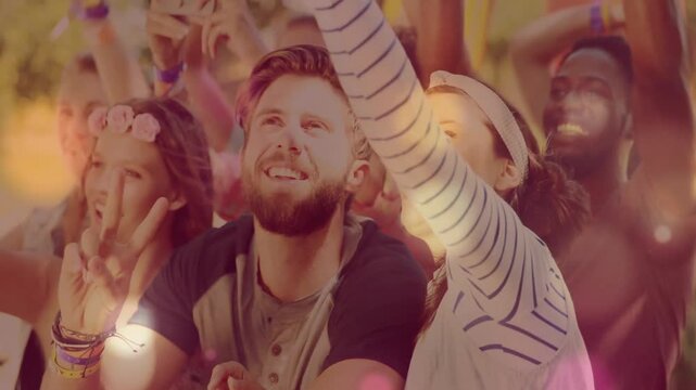 Front crowd cheering and filming on phone at music festival as performer cues, bokeh over faces