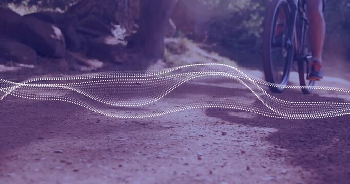 Male cyclist riding across trail for fitness, wheel hitting ground, kicking dust, waveform weaving