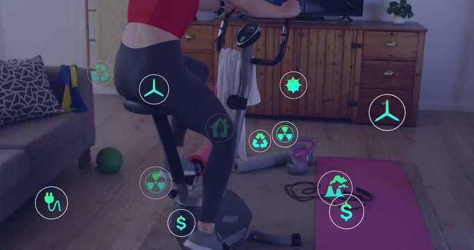 Vertical video: Pedaling woman in red bra on spin bike following TV at home with UI icons