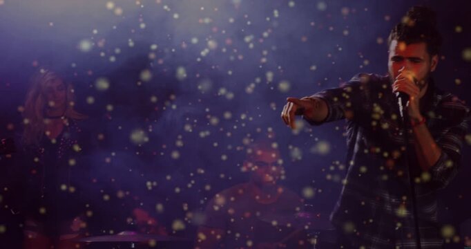 Vertical video: Lead singer entering right, raising mic, connecting crowd amid concert particles