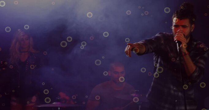 Vertical video: Entering from right plaid singer moving to stage pointing singing into mic to sing