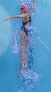 Vertical video: Frame timer starting top cam filming swimmer pink cap doing freestyle training