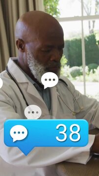 Vertical video: doctor watching medical chat alerts climbing, typing on laptop, managing messages