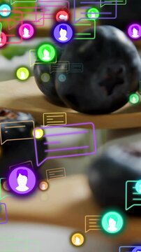 Vertical video: Blueberries on spoons, frame shifting, animated chat icons flowing over for food ad