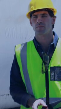 Vertical video: Construction inspector tapping tablet, projecting map and code, then surveying site