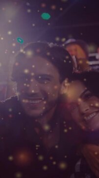 Vertical video: Center pair leaning posing as cam rising, capturing music selfie, golden overlay