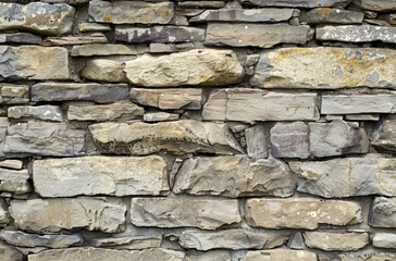 Fototapeta premium Photo of Old grey and brown stone wall. Background texture for backdrops or mapping