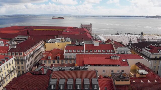 Drone panning over Pra&ccedil;a do Com&eacute;rcio with Rua Augusta Arch and Tagus river with boat in Lisbon Portugal