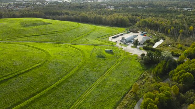 Drone footage revealing the lush green terraces of a reclaimed landfill hill in Tallinn, Estonia, showcasing a successful example of environmental restoration and land recycling