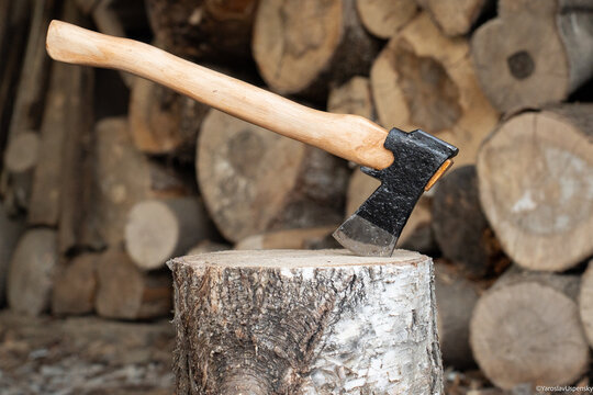 Traditional black finish Finnish axe stuck in a birch log for splitting firewood