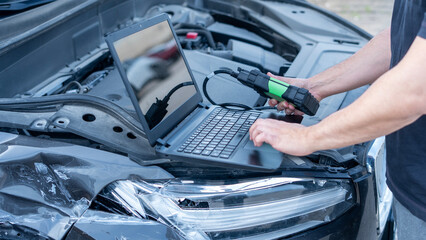 mechanic man at auto service using check up device