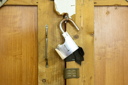 Broken padlock on damaged wooden door