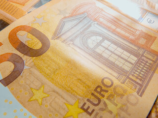 Explore the fascinating details of a 50 euro banknote with an extreme close up that showcases its vibrant colors, security features, and artistic elements.