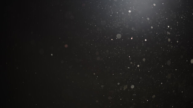 Real dust particles floating in air over dark background