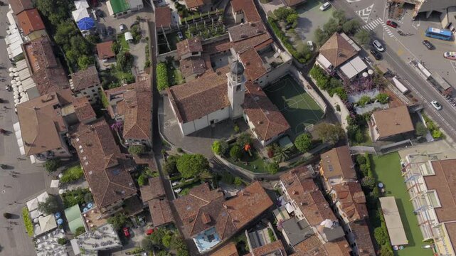 Aerial drone footage transitioning from top-down view to horizontal perspective of a church in Limone sul Garda, with Lake Garda and surrounding mountains creating a scenic backdrop.