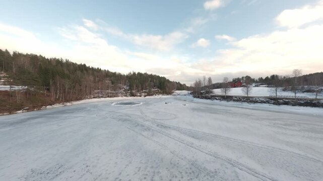 Aerial FPV view of icy lake and hills in Telemark Norway