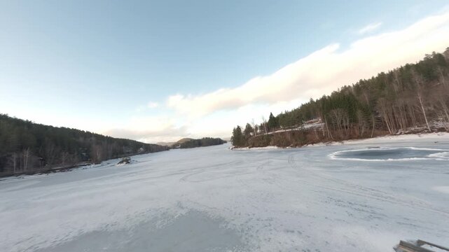FPV drone flying over frozen lake in Telemark Norway winter landscape