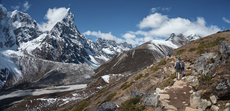 Panoramic View of the Snowy Himalayan Range with Adventurous Trekkers on the mountain Trail to Mount Everest Base Camp. Nepal