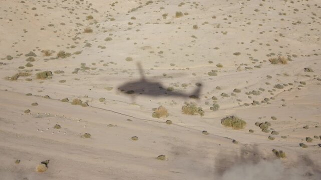 Shadow of black hawk helicopter on the ground