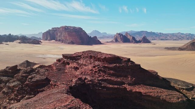 Drone over rock revealing big maountains in wadi rum desert in jordan