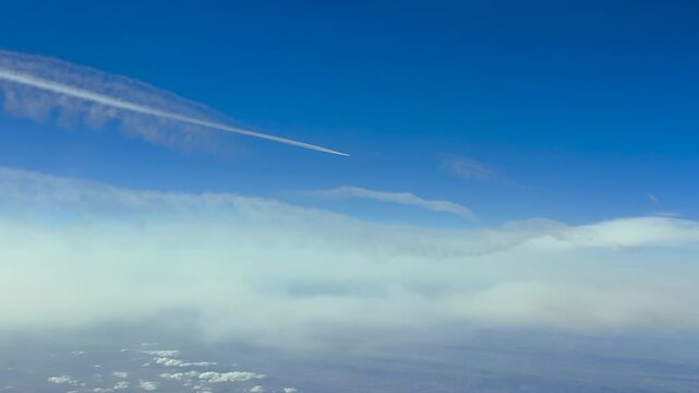 Aerial view taken from a jet airplane cockpit flying in the upper atmosphere at 120000m high in a blue sky.