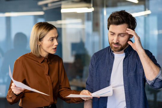 Angry female boss criticizing male employee for bad performance