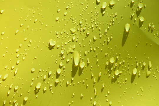 Green water drops with ripples on the surface. Defocus blurred transparent blue colored clear calm water surface texture with splashes and bubbles. Water waves with shining pattern texture background.