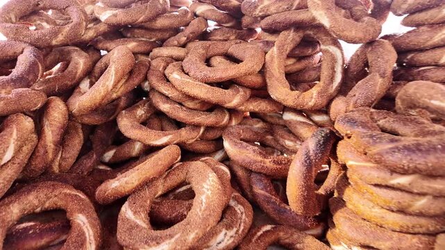 Turkish bagel simit, traditional freshly baked sesame street food, stacked high with motion.