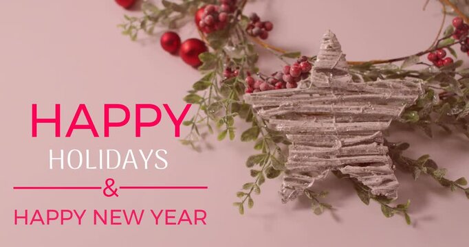 Animation of happy holidays and text banner over red cherries and star decoration on pink surface