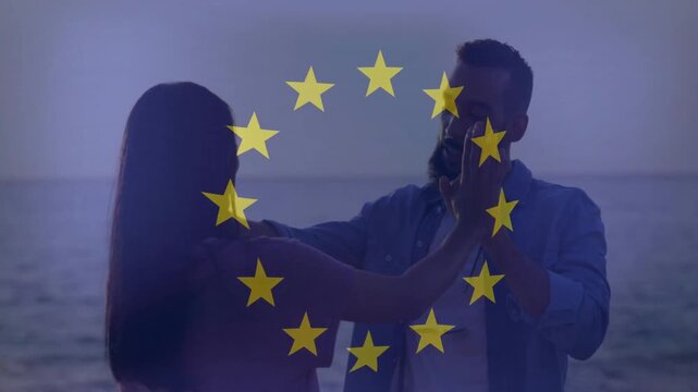 Embracing by ocean, couple with European Union stars overlay in animation
