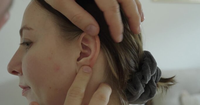 Close-up of a doctor examining a woman's ear. Concept of healthcare, medical check and ear examination.