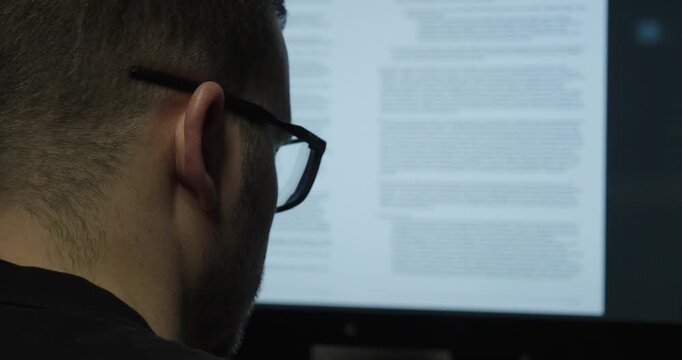 Man carefully reviewing contract terms on a computer screen. Concept of legal analysis, business agreement and document check.
