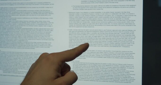 Close-up of a finger pointing at contract terms on a screen. Concept of legal review, agreement and business analysis.