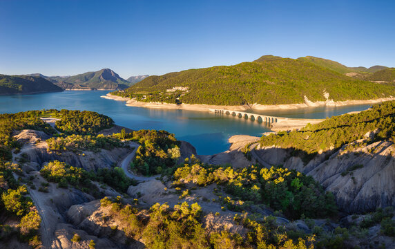 Aerial view of Serre-Poncon Lake with Chanteloube Bay and abandonned arched railroad bridge. Durance Valley in Hautes-Alpes (French Alps), France