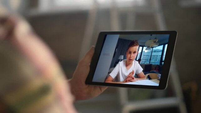 Smart kid speaking videochat tablet screen at flat closeup. Man holding computer