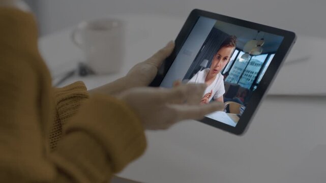 Child studying videochat screen tablet at cafe closeup. Woman hands holding tab