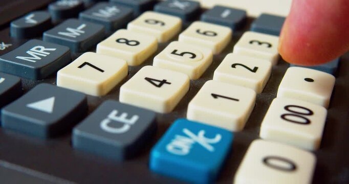 Macro shot of a finger pushing calculator buttons.Modern business  