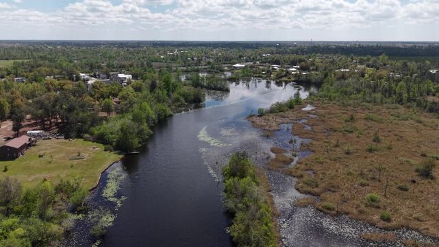 Aerial landscape of winding river cutting through green and rural wetlands, 30A, Florida, USA