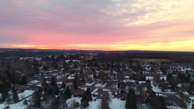 Community Neighbourhood In The Town Of Alton During Winter At Sunrise In Caledon, Ontario. Aerial Flyover.