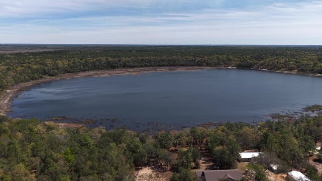 Huge lake surrounded by dense forest creating natural circular landscape formation at 30A area, Florida, USA