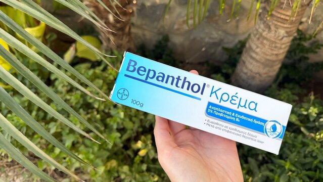 Limassol, Cyprus - March 30, 2026 Bepanthen skincare box and tube in hand outdoors. Medical healing product and essential first-aid skincare concept.