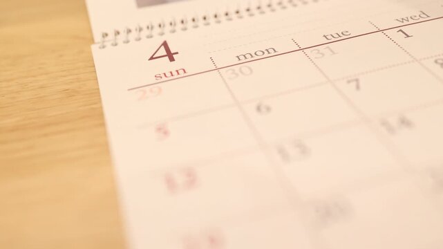 カレンダーを捲る動き・3月から4月へページをめくるクローズアップ